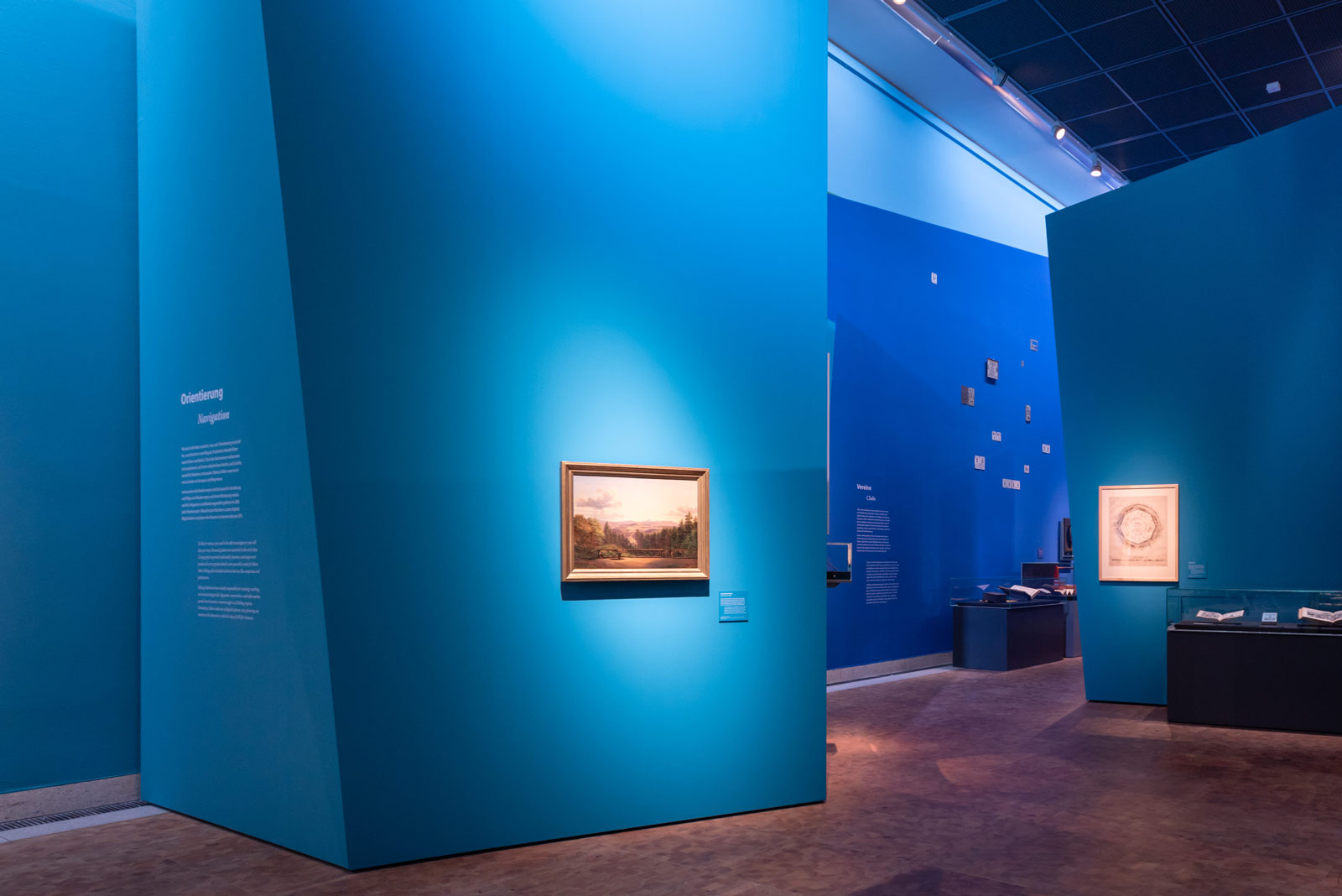 Das Referenzbild für Ausstellungsgestaltung aus der Sonderausstellung Wanderland zeigt eine Bildergalerie im markanten Farbkonzept der Ausstellung.