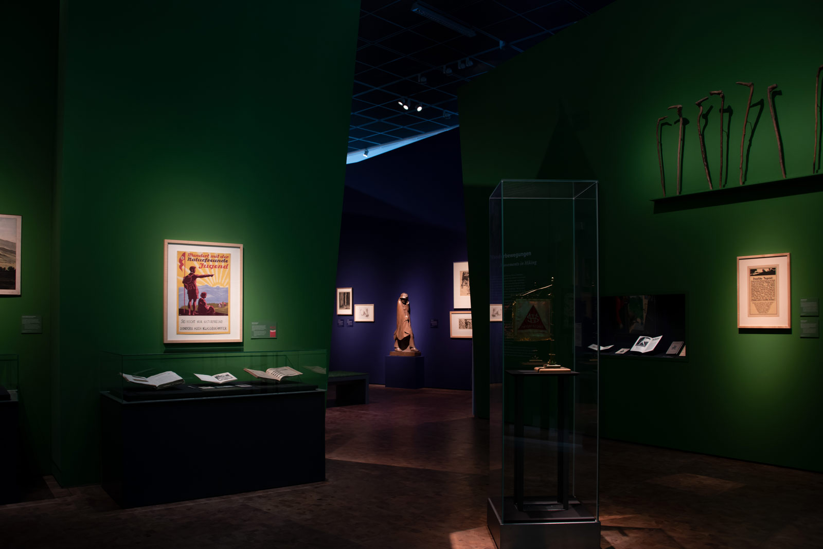 Das Referenzbild für Ausstellungsgestaltung aus der Sonderausstellung Wanderland zeigt eine Exponat-Präsentation mit Wandvitrine und Ganzglas-Vitrine.