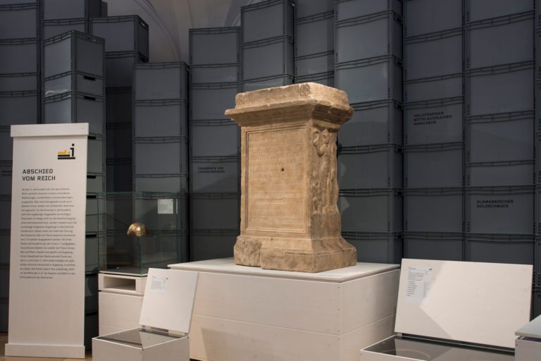Das Referenzbild für Ausstellungsgestaltung aus der Interimsausstellung „Römerlager – Das Römische Augsburg in Kisten“ zeigt eine Exponatpräsentation.