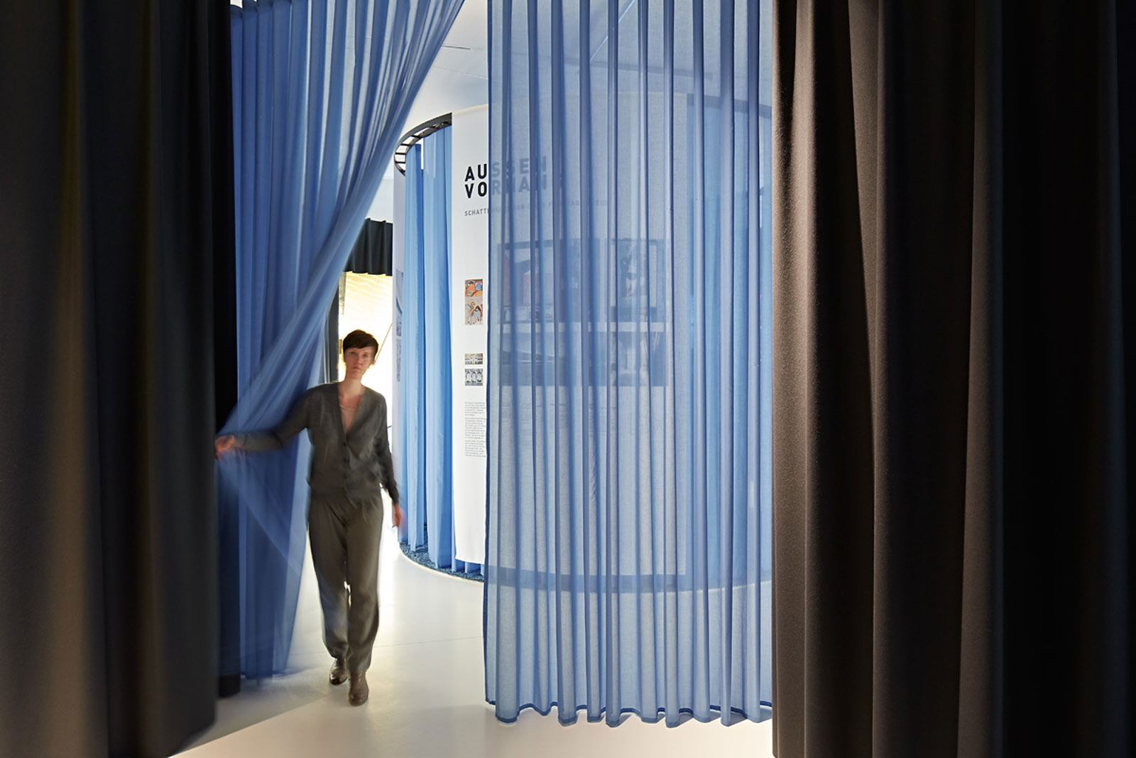 Das Referenzbild für Ausstellungsgestaltung aus der Sonderausstellung „Textile Architektur“ zeigt eine Medienstation mit ein Raumtrenner.