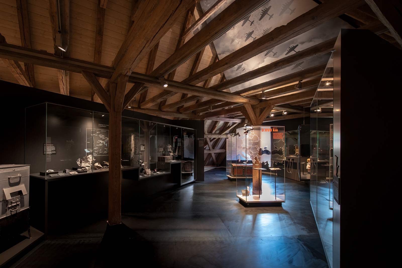 Das Referenzbild für Ausstellungsgestaltung aus der Dauerausstellung Tradition und Umbruch zeigt eine Rauminszenierung mit Ganzglas-Vitrinen.