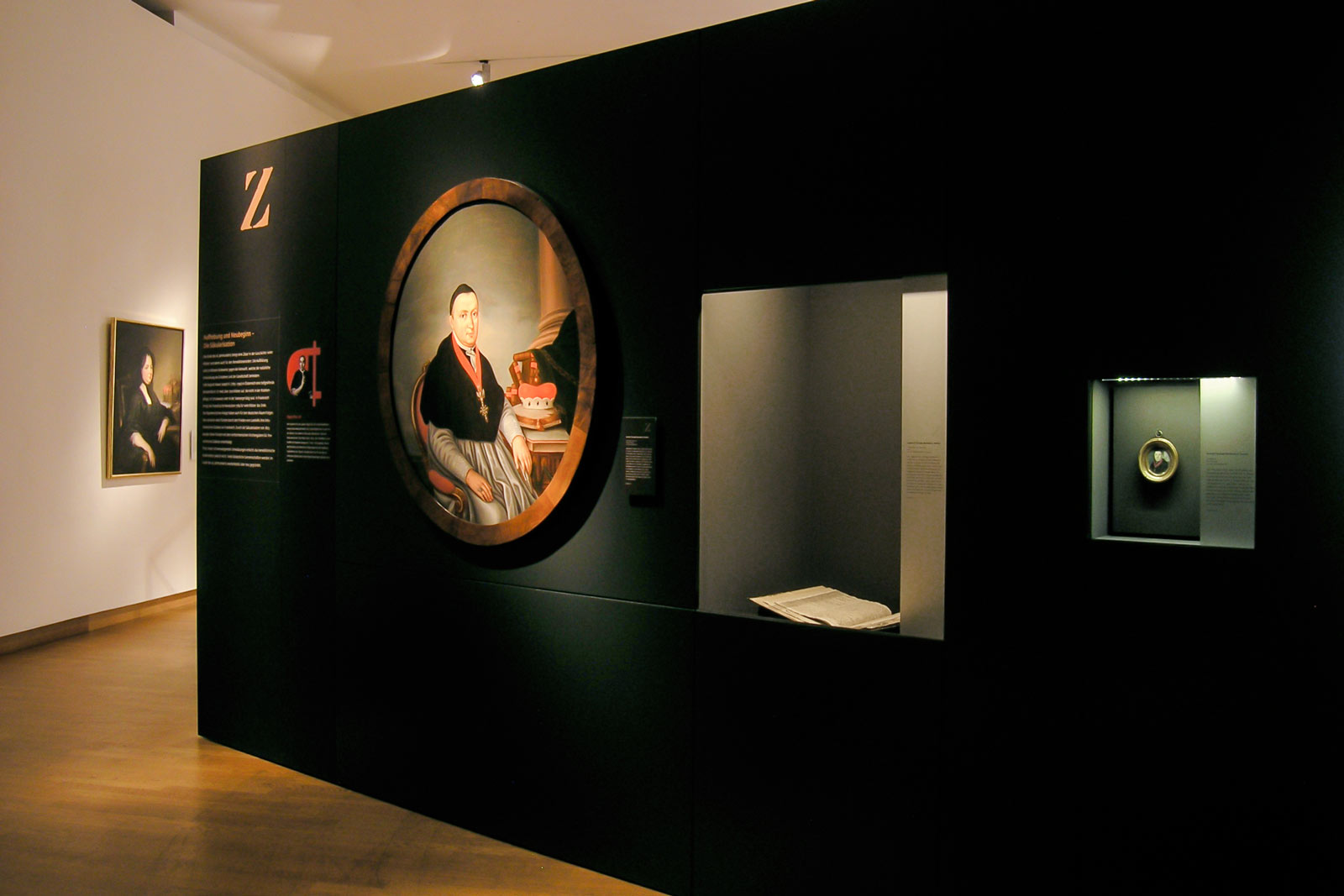 Das Referenzbild für Ausstellungsgestaltung aus der Sonderausstellung „Macht des Wortes“ zeigt Einbauvitrinen mit Exponatlicht.