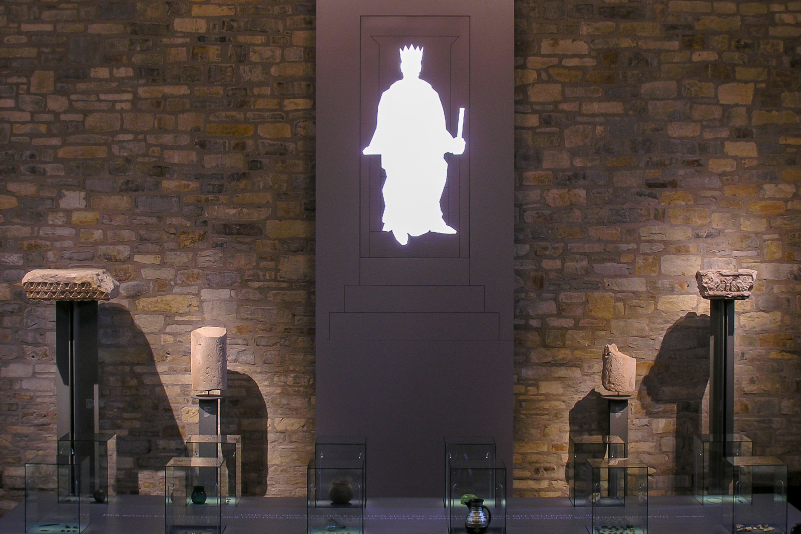 Das Referenzbild für Ausstellungsgestaltung aus der Dauerausstellung „Der Kaiser kehrt zurück“ zeigt eine Rauminszenierung mit Exponatpräsentation.