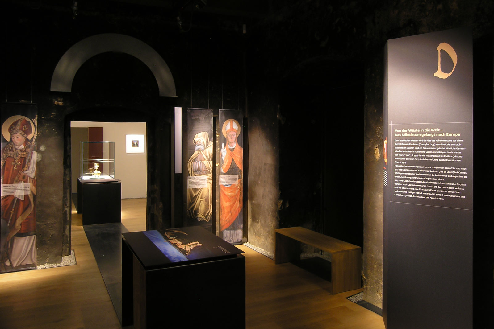 Das Referenzbild für Ausstellungsgestaltung aus der Sonderausstellung „Macht des Wortes“ zeigt ein Vitrinenband und Ausstellungsgrafiken.