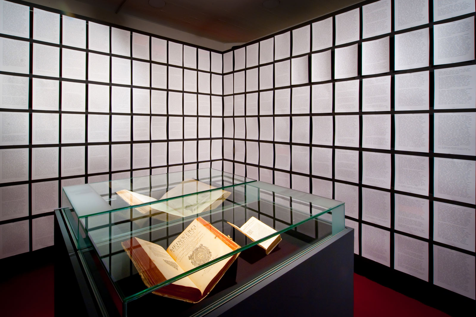 Das Referenzbild für Ausstellungsgestaltung aus der Sonderausstellung „Für Königtum und Himmelreich“ zeigt eine Rauminszenierung mit Tischvitrinen.