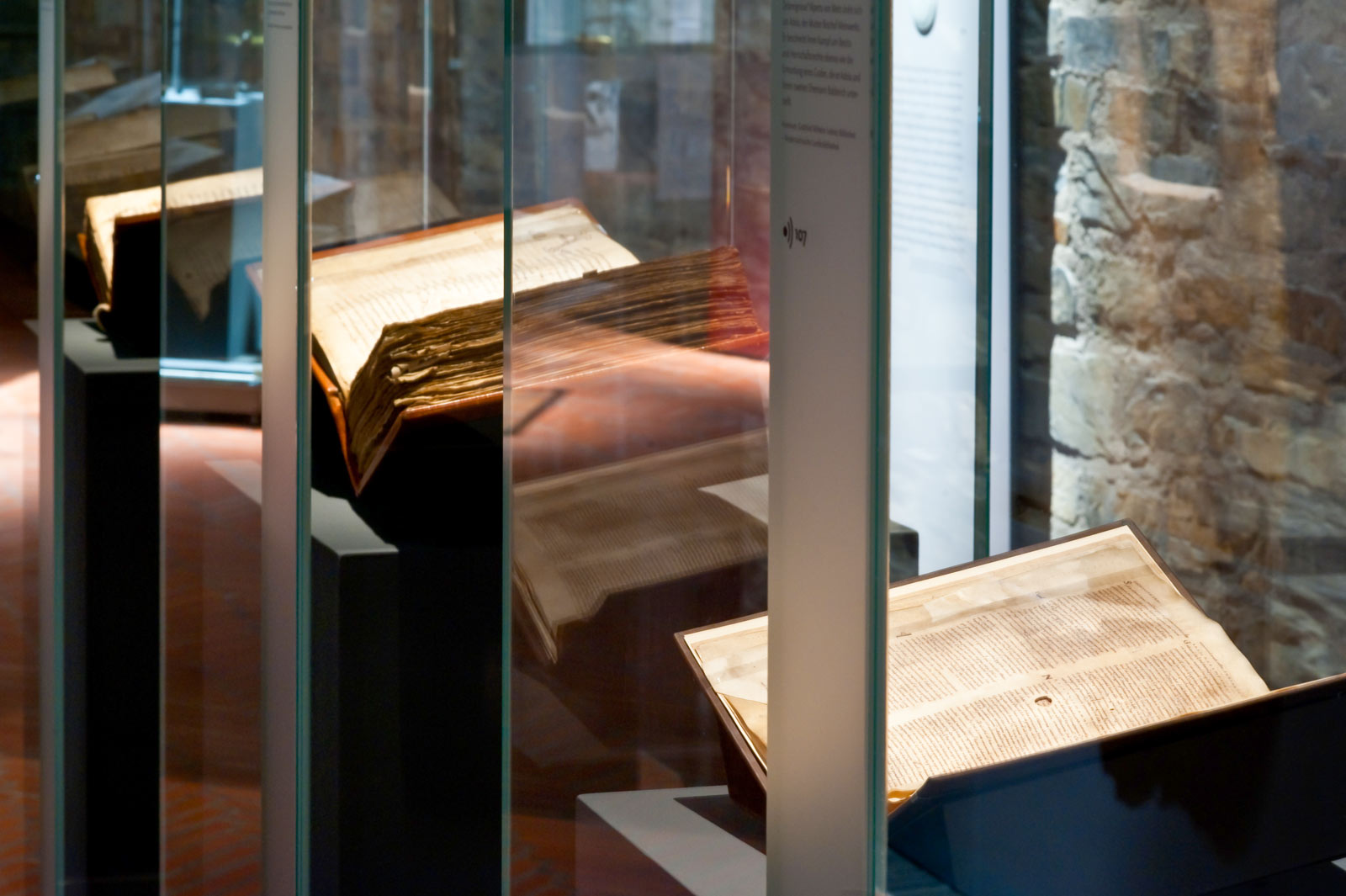 Das Referenzbild für Ausstellungsgestaltung aus der Sonderausstellung „Für Königtum und Himmelreich“ zeigt eine Exponatpräsentation mit einer Buchlege.