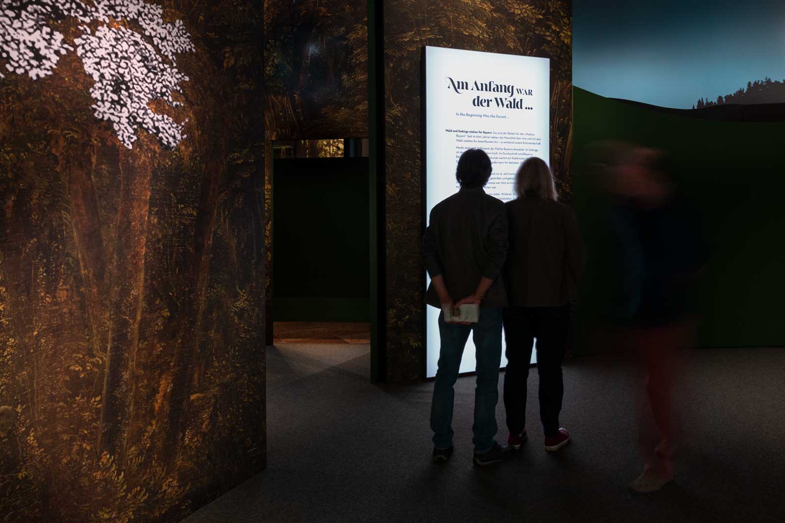 Das Referenzbild für Ausstellungsgestaltung aus der Sonderausstellung Wald, Gebirg und Königstraum – Mythos Bayern zeigt eine Rauminszenierung mit Leuchtkästen.