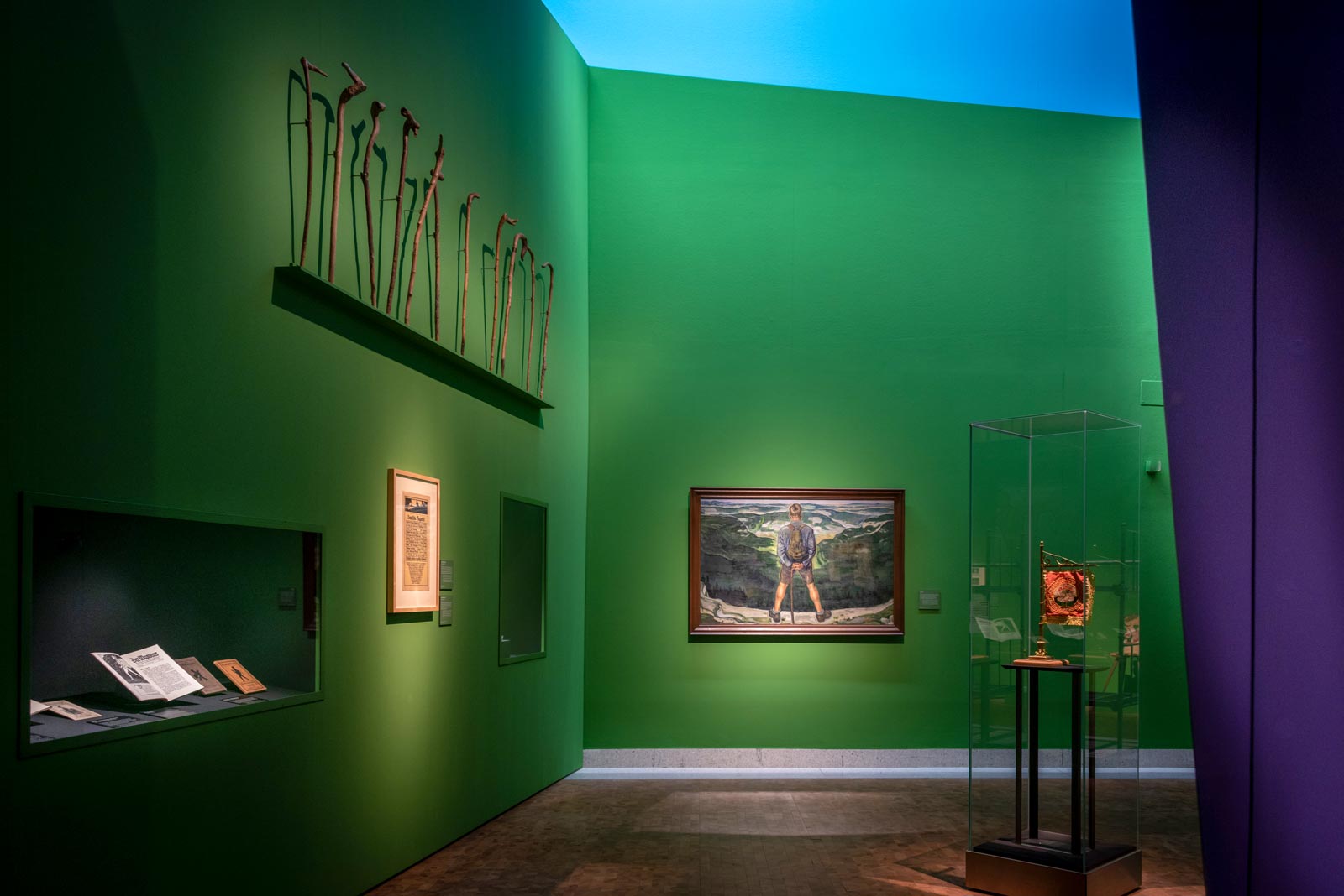 Das Referenzbild für Ausstellungsgestaltung aus der Sonderausstellung Wanderland zeigt eine Exponat-Präsentation mit Wandvitrine und Ganzglas-Vitrine.